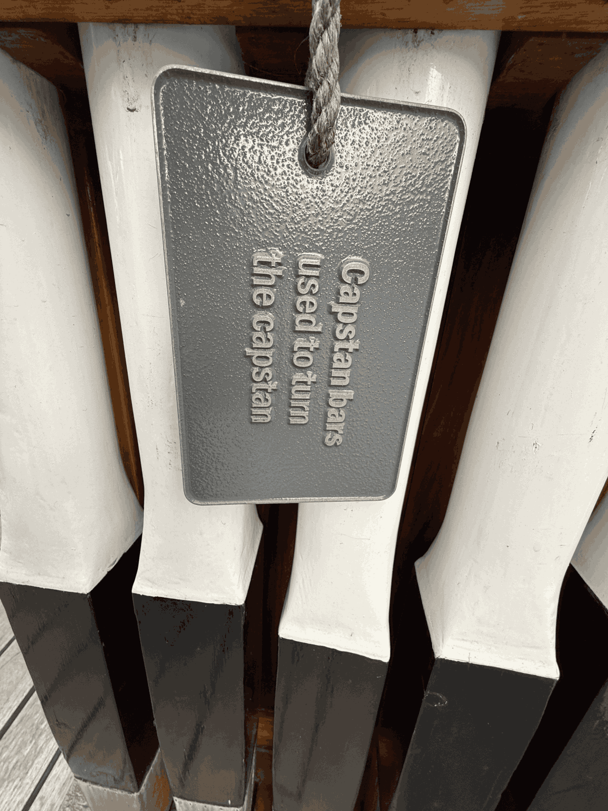 Multiple capstan bars stored along the ship deck
